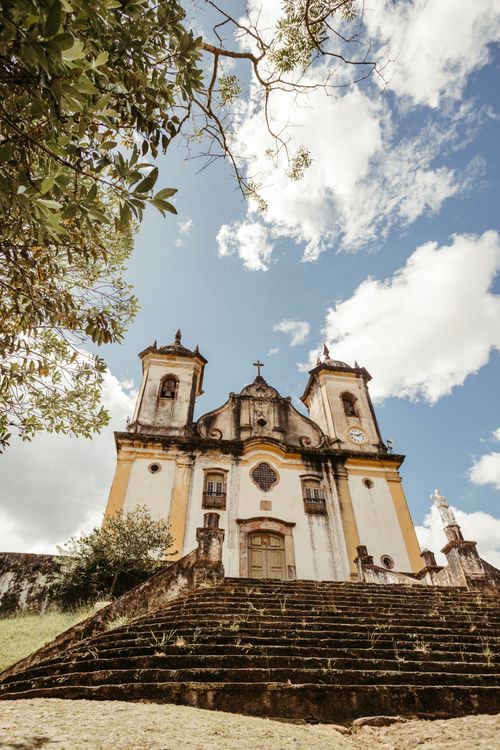 Free Low-angle view of a Baroque church in Brazil with a clear blue sky backdrop, showcasing historic architecture. Stock Photo