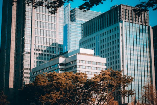 View of modern skyscrapers in Tokyo's bustling financial district with clear blue sky.