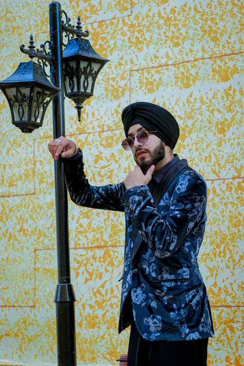 Man Wearing Turban and Sunglasses, Leaning against a Lamp Post 