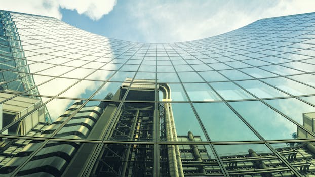现代玻璃建筑的低角度视图映照出工业结构与天空
