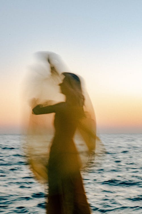 Blurred Woman on Sea Shore at Sunset