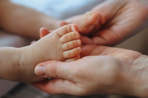 Close-up of Mother Holding the Feet of a Newborn Baby 