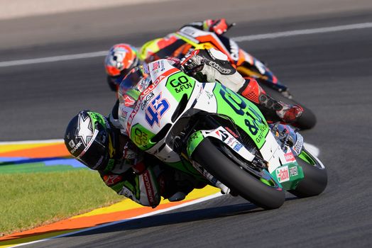 Competitive motorcycle race showcasing skilled racers on track.