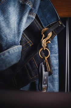 Golden eagle keychain attached to blue denim jeans, showcasing unique style and craftsmanship.