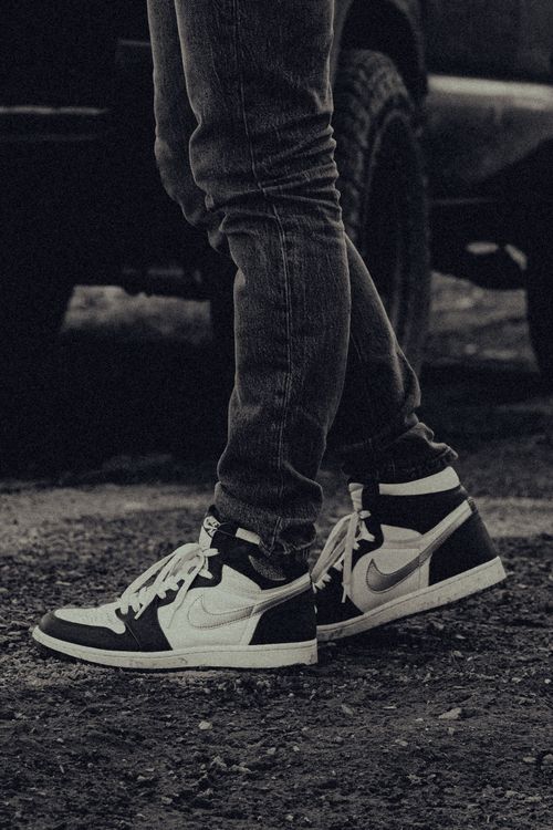 Free Close-up image of trendy sneakers paired with casual jeans, showcasing modern streetwear fashion. Stock Photo