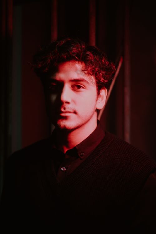 Free Moody portrait of a young man under dramatic red lighting indoors. Stock Photo