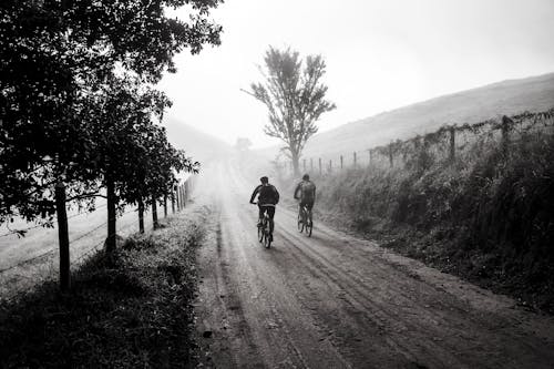 Grayscale Photography of Two Person Biking