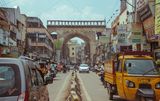 Vibrant Hyderabad street scene with traffic, shops and an archway