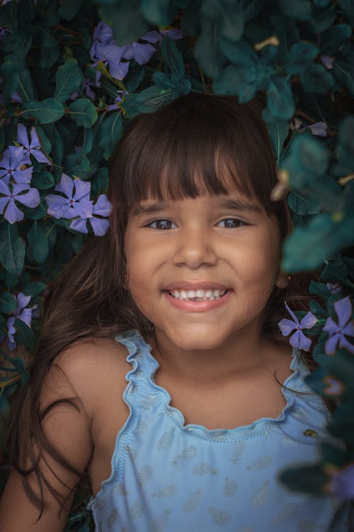 Smiling Girl in Floral Shrub