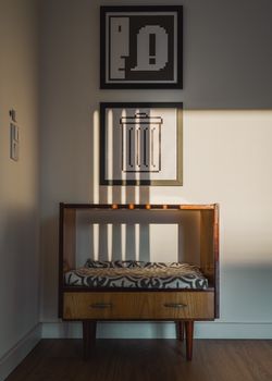 Cozy mid-century modern furniture illuminated by sunlight, featuring geometric artwork and a warm wooden floor.. pexels, cozy