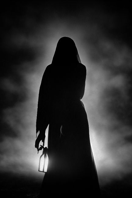 A captivating silhouette backlit by fog, holding a lantern, creating an eerie and mysterious atmosphere.
