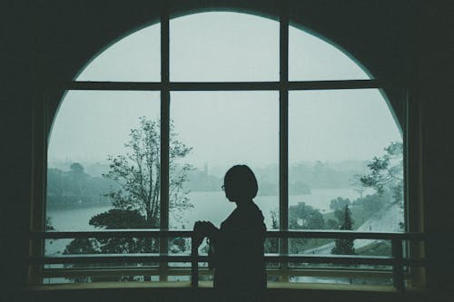 Woman Standing Beside Window