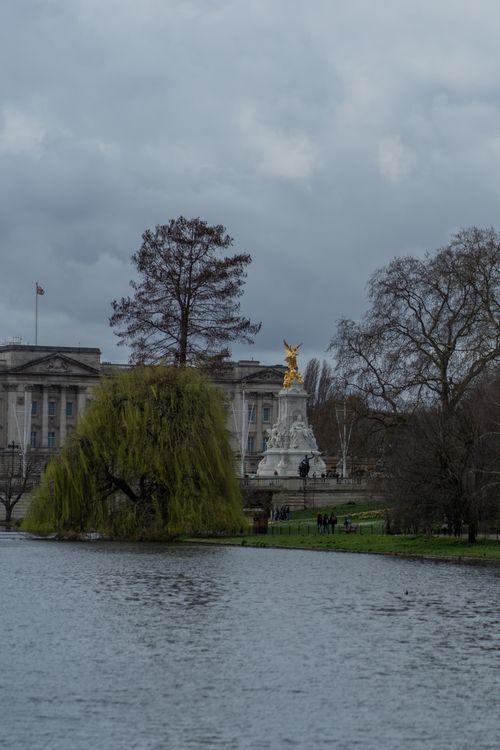 Free Captivating shot of Buckingham Palace with the Victoria Memorial and serene St James's Park lake in London. Stock Photo