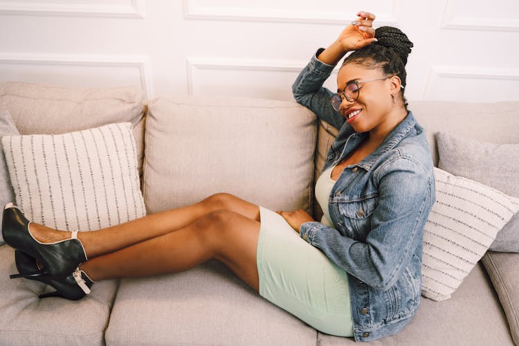 Woman In Jean Jacket Sitting On Couch