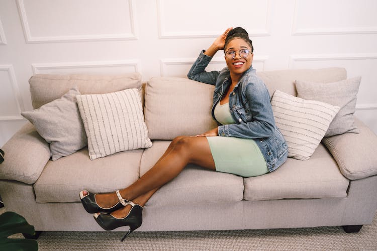 Woman In Jean Jacket Sitting On Couch