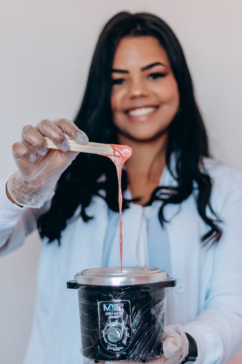 Free Female Beautician Preparing Wax in a Wax Heater Stock Photo