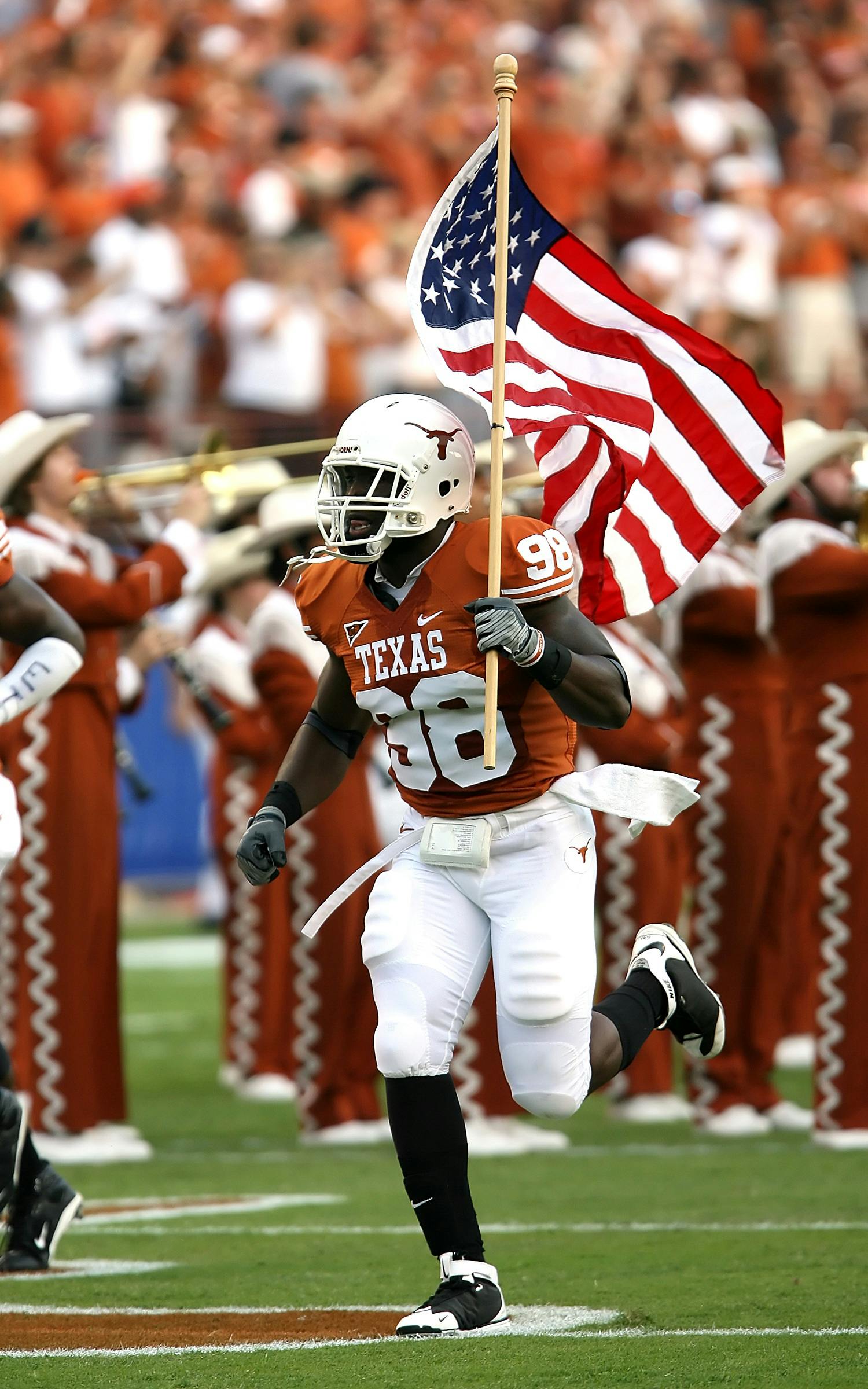 nfl player holding u s a flag on field