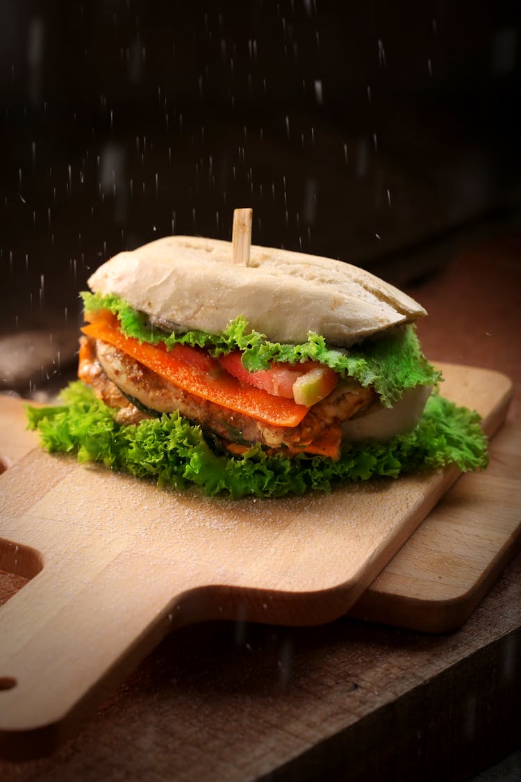 Burger On Top Of Brown Chopping Board