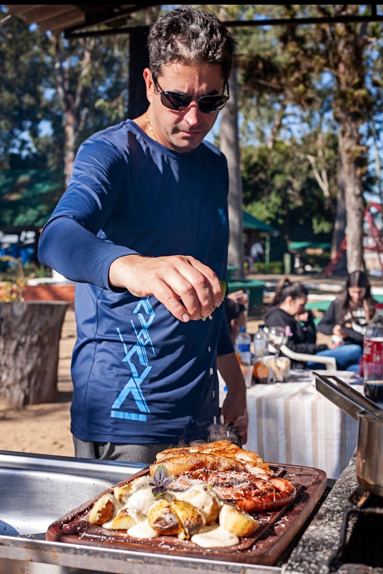 Man Cooking Barbecue In Summer Park