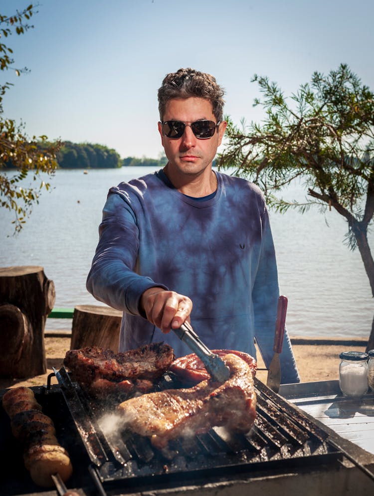 Photo Of A Man Doing Barbecue By The Sea