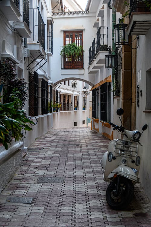 Photo of a Narrow Street with a Scooter in an Old Town