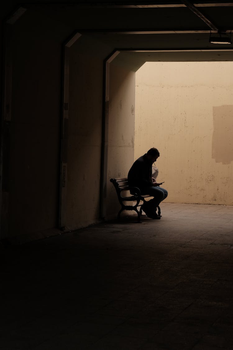 Person Sitting On Bench In Tunnel