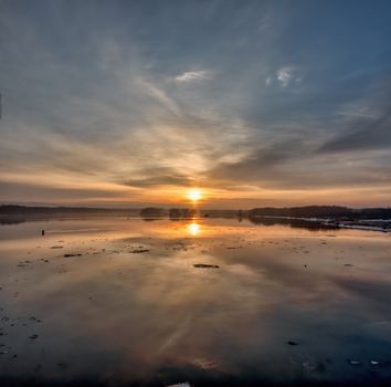 A tranquil sunset over a calm lake in Reads Landing, MN, capturing the beauty of nature.
