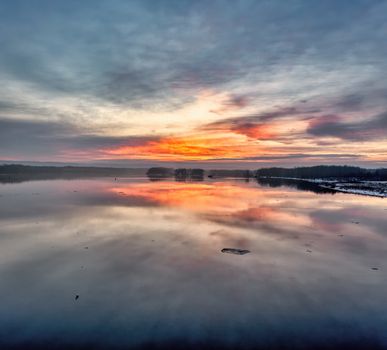 Breathtaking sunset with vibrant reflections over a tranquil lake in Reads Landing, MN.