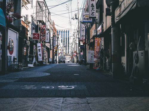 Free A quiet urban alley lined with traditional Japanese signs and buildings. Stock Photo