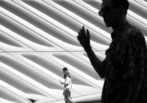 Pedestrian by Facade of Modern Building