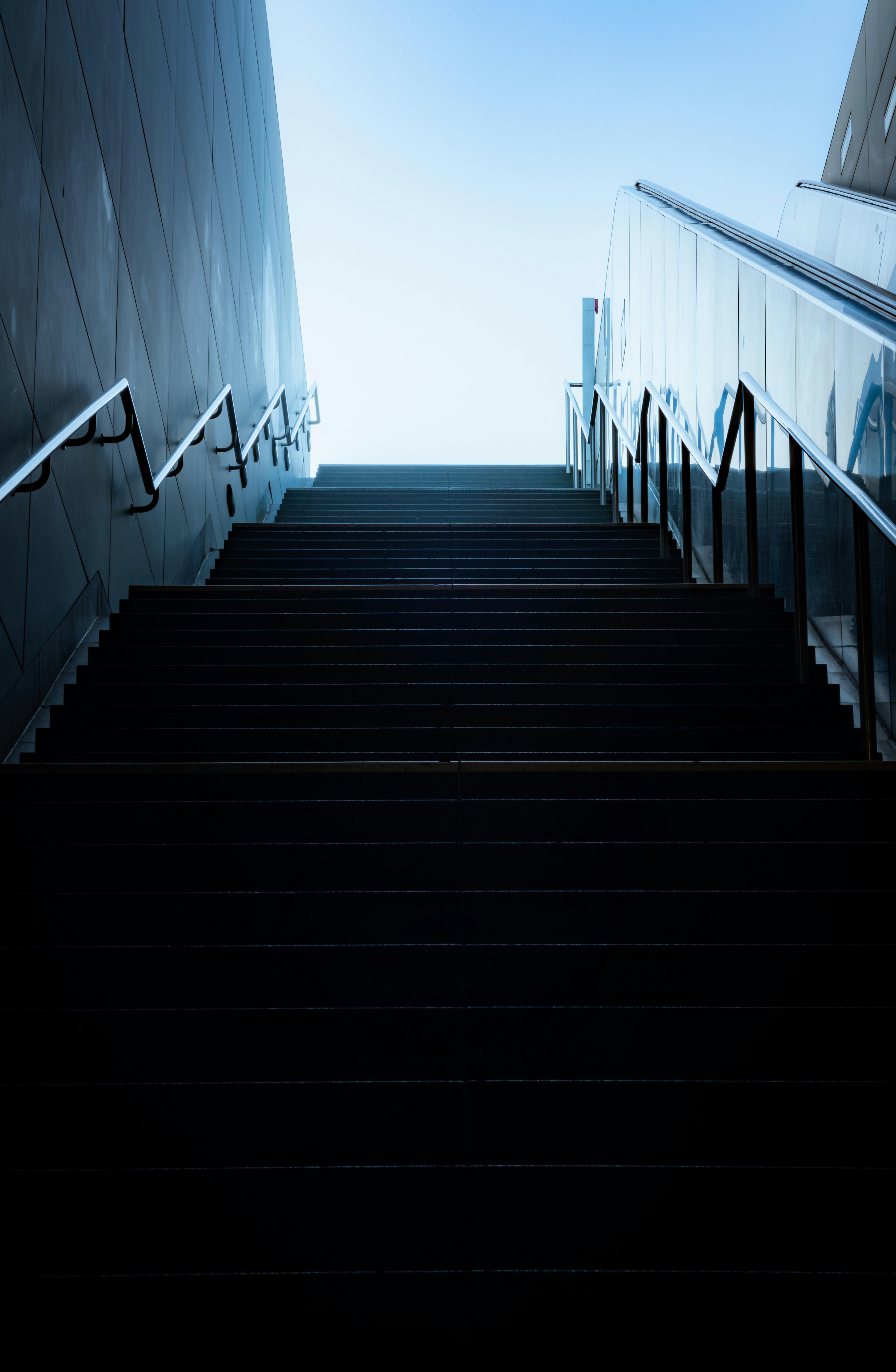 a stairway leading up to a building with a blue sky