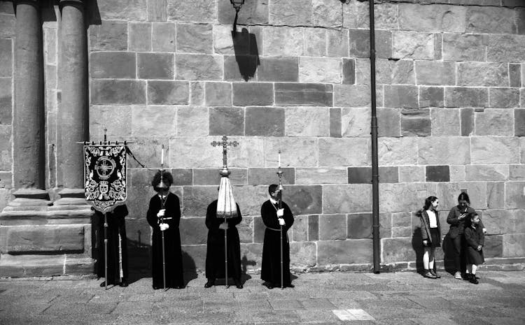 People In Gowns With Cross Standing Near Children At Church