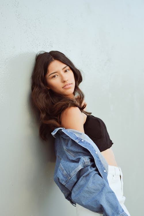 Brunette Woman with Denim Jacket Leaning Against Wall