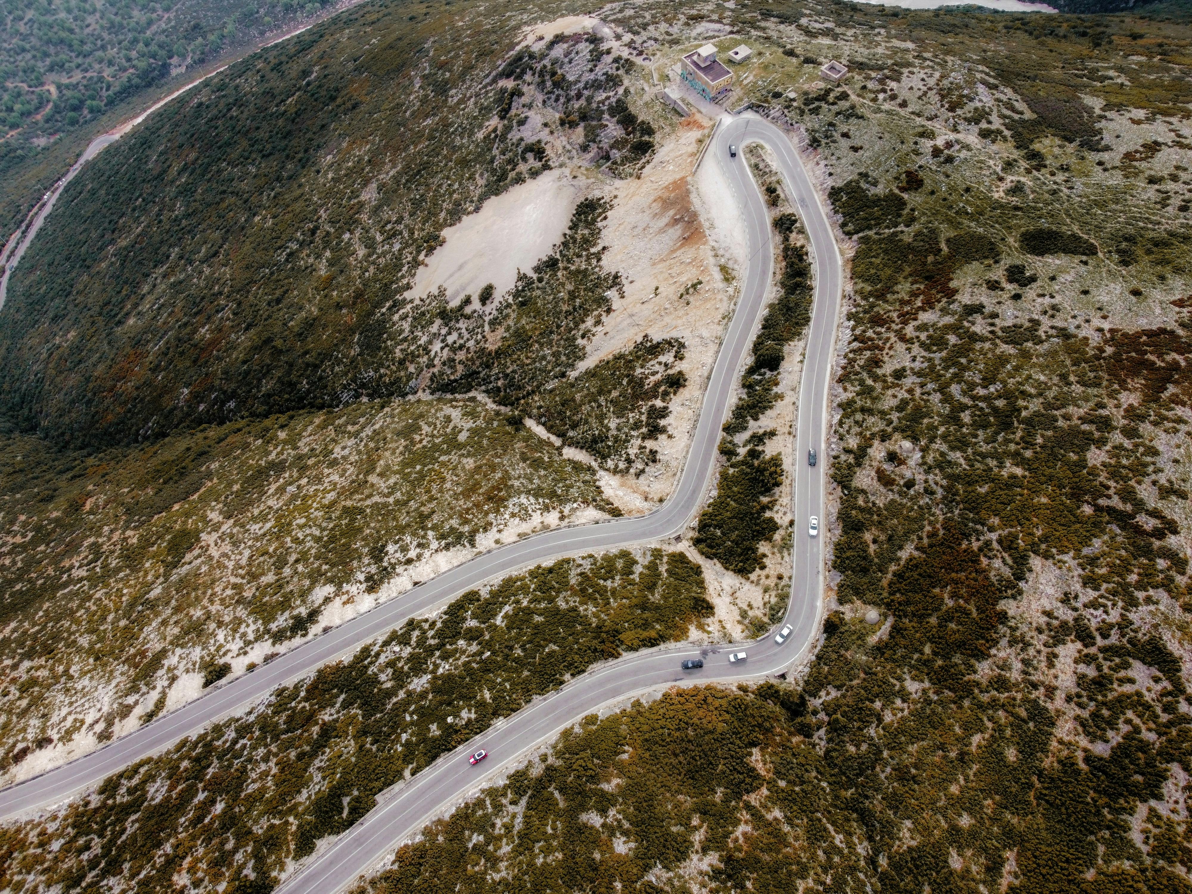 Captivating aerial shot of a winding road through autumn landscapes on a mountain.
