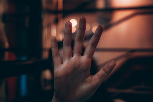 Free Close-up of a hand gesture against a moody bokeh background, creating a dramatic effect. Stock Photo