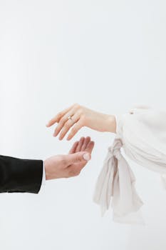 A minimalist photo featuring bride and groom exchanging rings with focus on delicate hands.