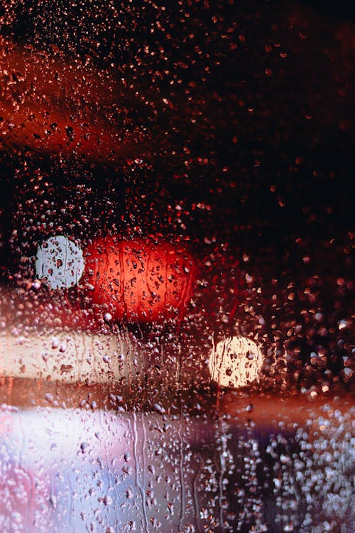 Close-up of a Wet Window and Blurry Lights 