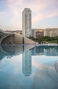 日落时分，摩天大楼和城市天际线倒映在宁静的湖水中