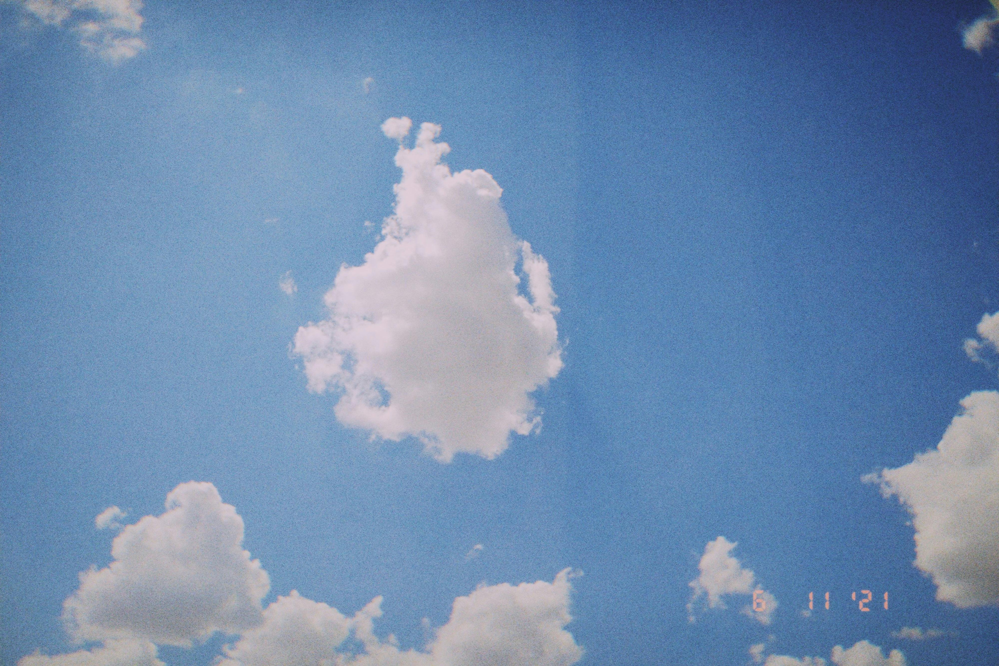 Serene view of a bright blue sky dotted with fluffy white clouds in daylight.