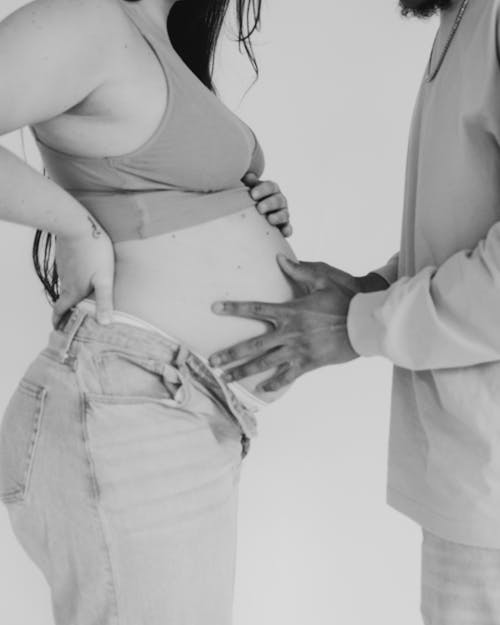 Man Holds Hands on Belly of Pregnant Woman