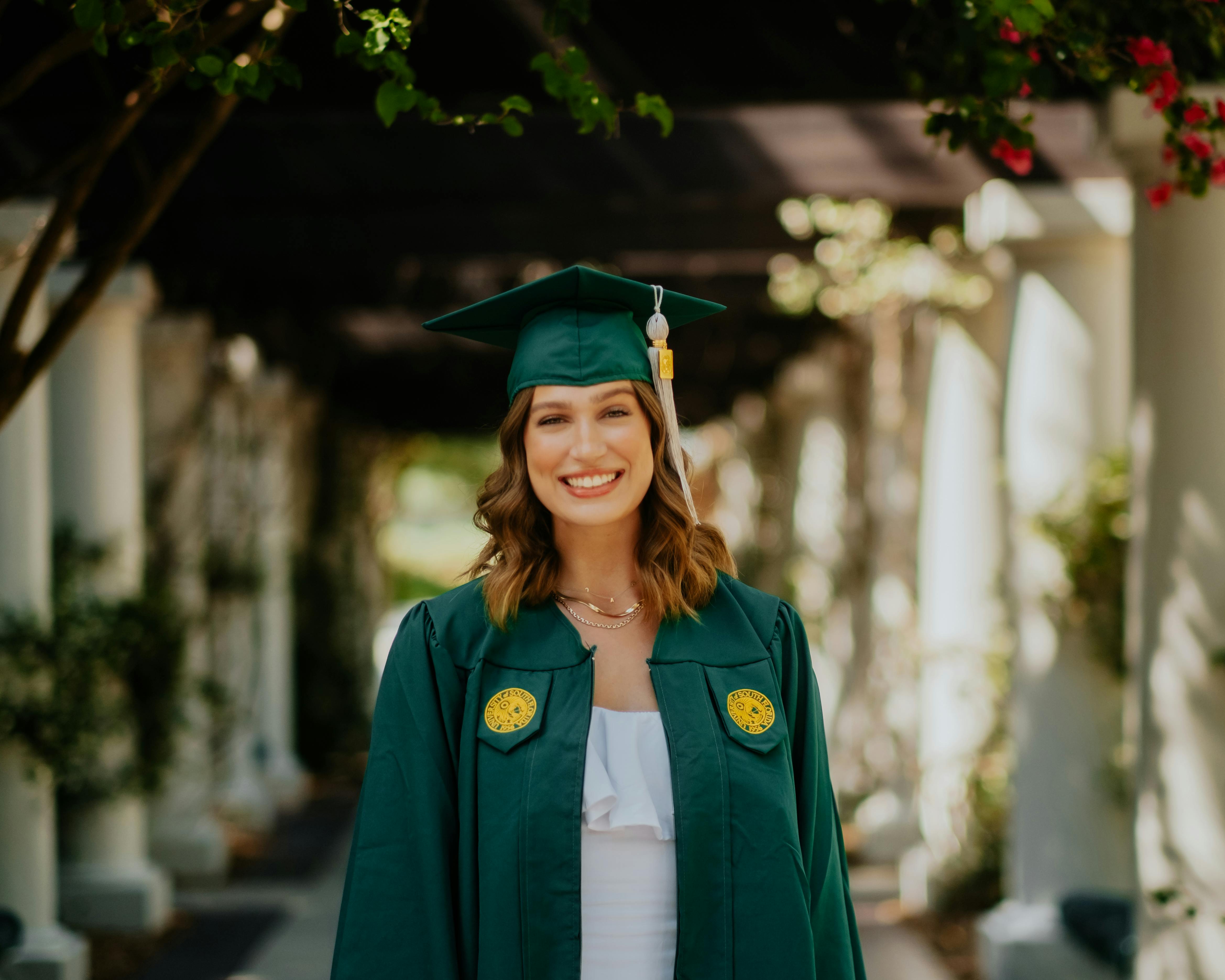 a beautiful woman in a green graduation gown