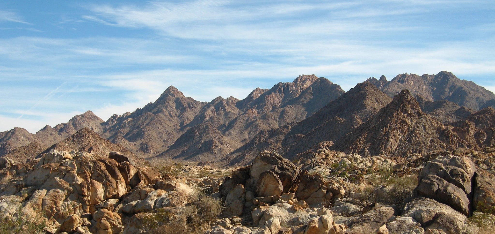 landscape photography of brown mountain under white and blue cloudy sky during daytime