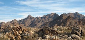 在清澈的蓝天下，探索岩石沙漠山脉的崎岖之美，捕捉大自然的纯粹优雅