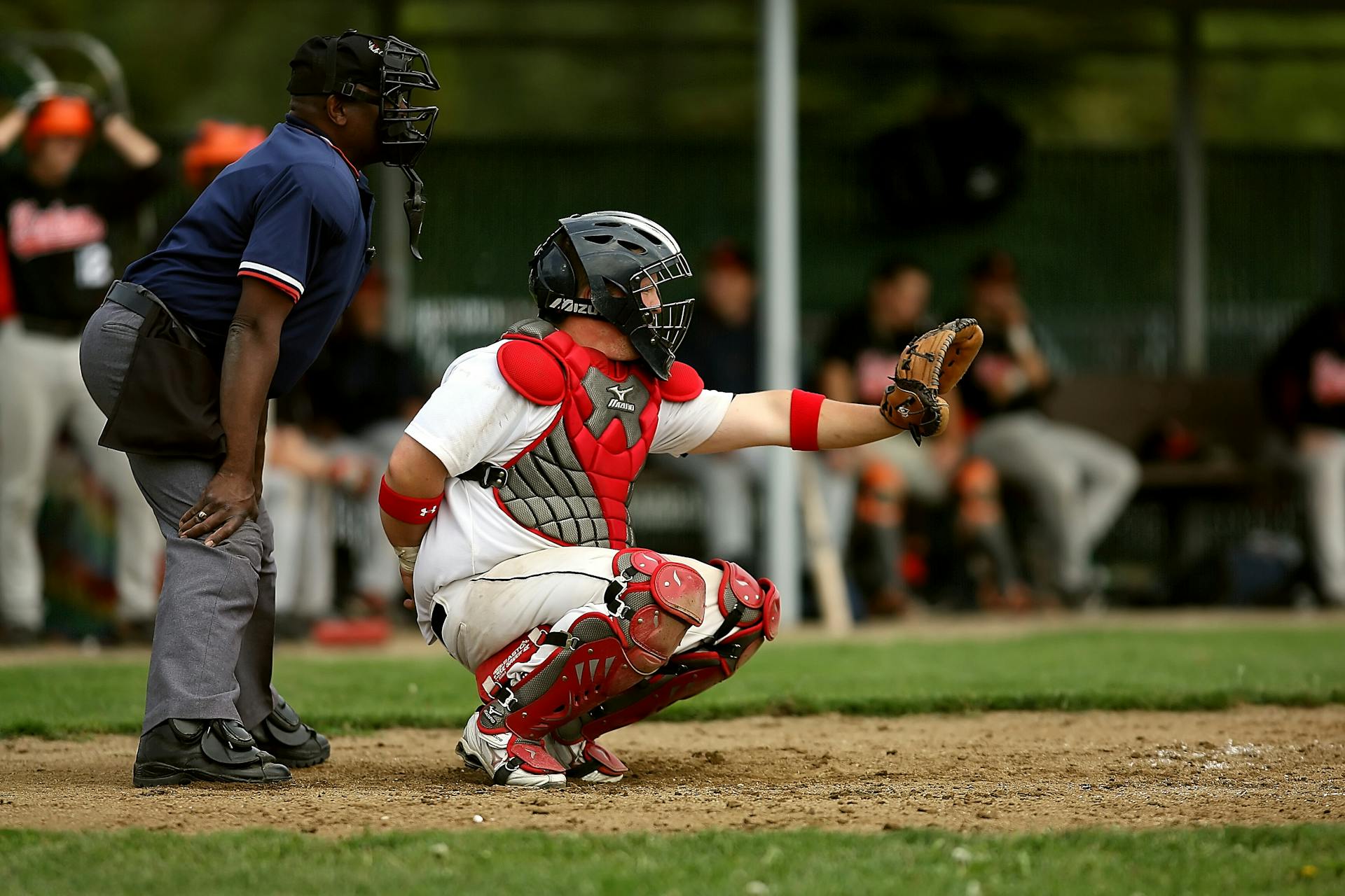 White and Red Baseball Player With Black Face Helmet and Brown Leather Mitts