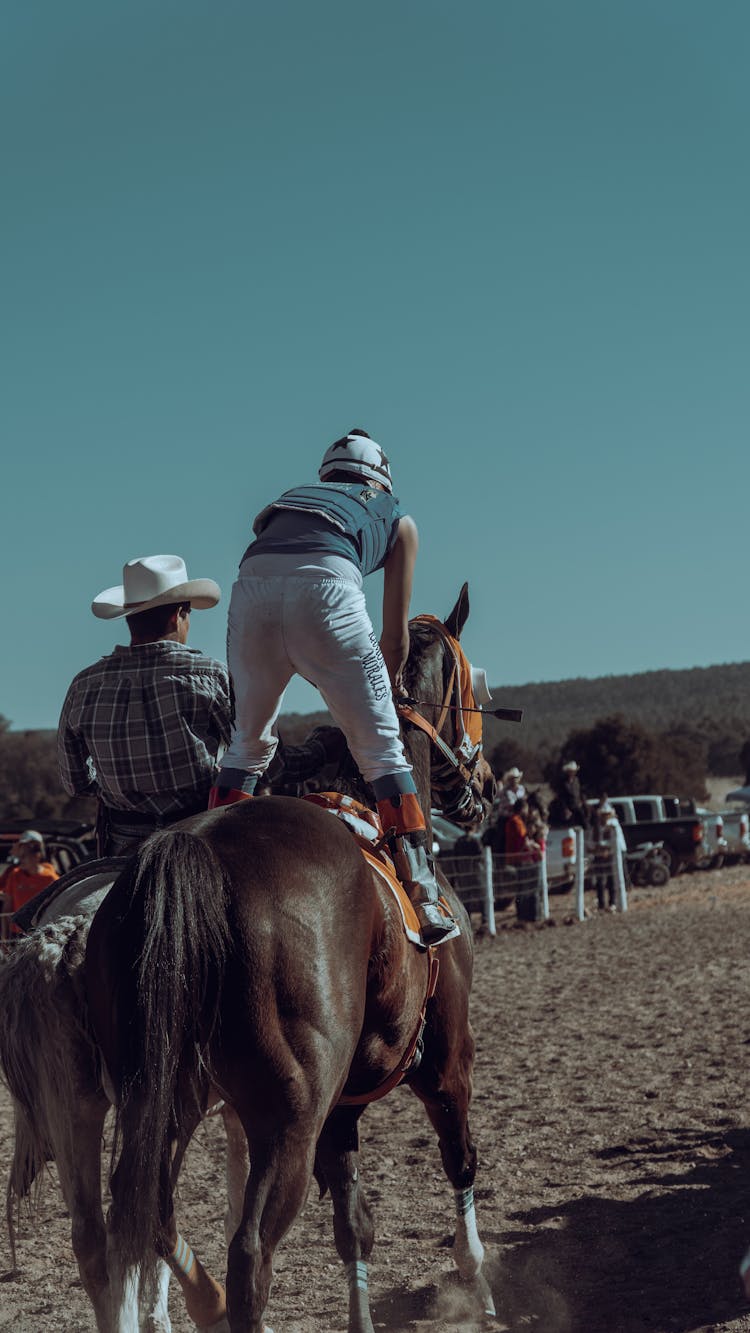 Back View Of Cowboy And Jockey On Horses