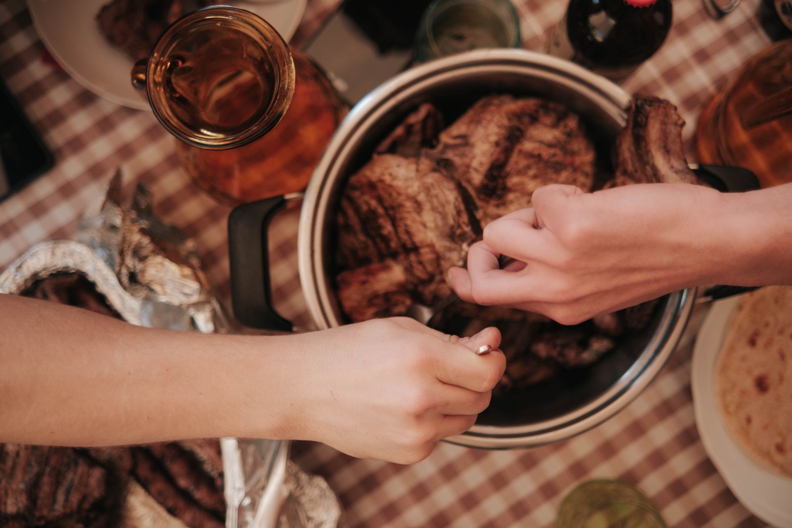 Sunday roast being served from a pot onto plates