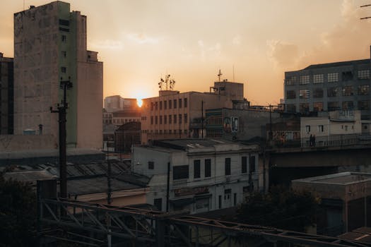 Cityscape view with sunrise casting warm light on urban buildings.