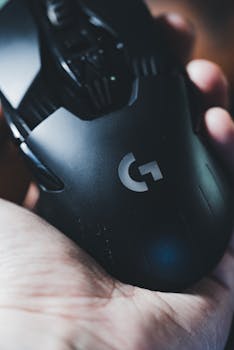 Detailed shot of a hand holding a sleek gaming mouse, emphasizing design and ergonomics.