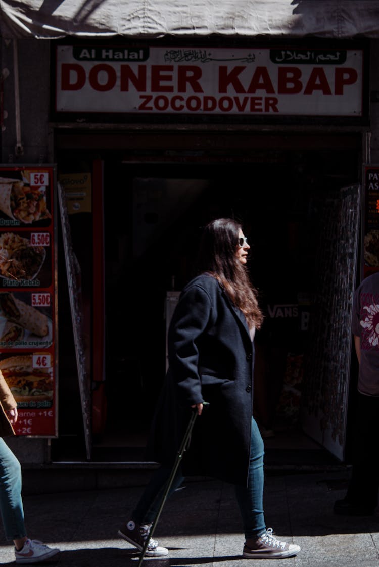 Woman Walking Near Kebab Restaurant