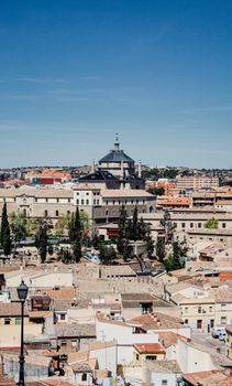 A scenic aerial view capturing Toledo's historic rooftops and architecture under a clear blue sky.
